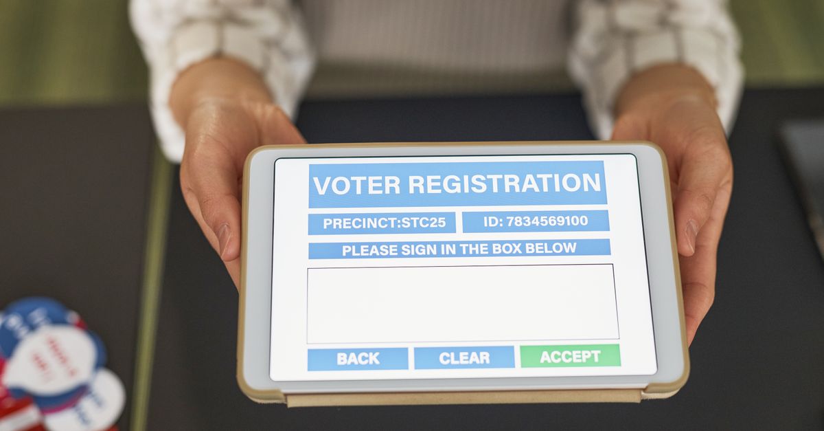 Close-up of hands holding a tablet displaying digital voter registration form.